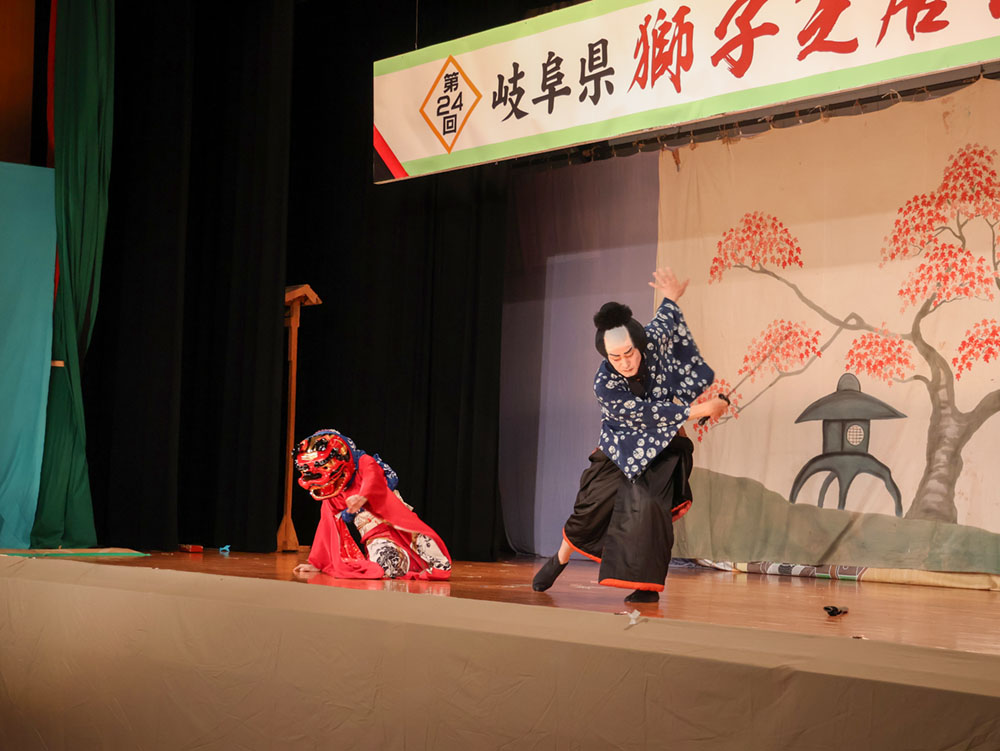 刀で切られる場面を演じる獅子頭をかぶった役者ら