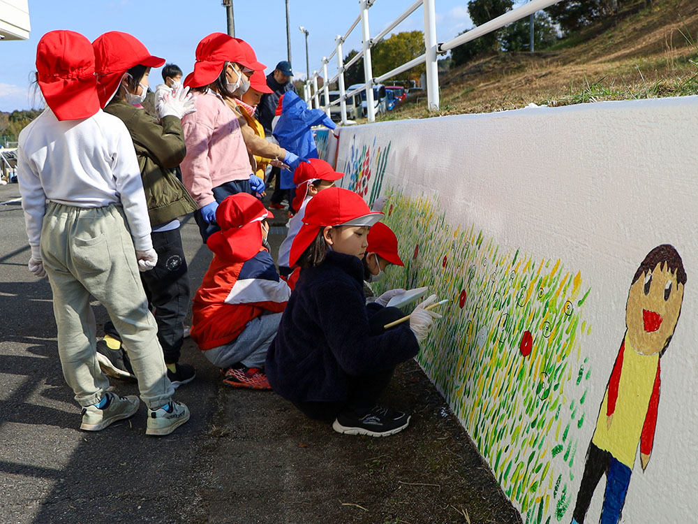 壁画に色塗りをする1年生の児童ら