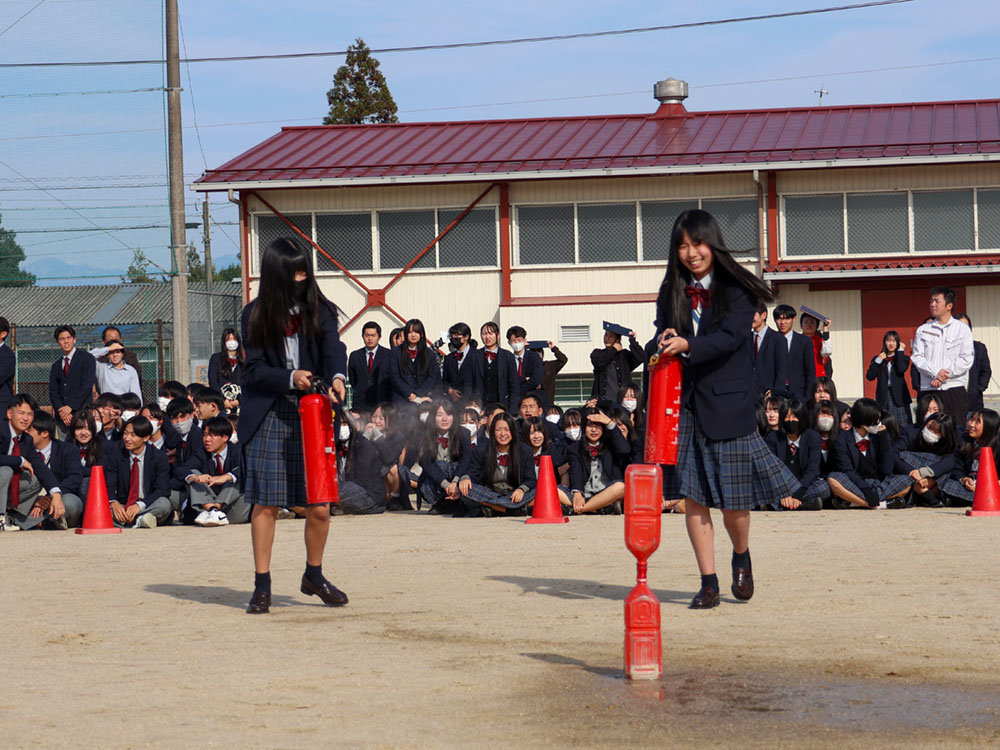 消火器の取り扱い訓練をする女の子
