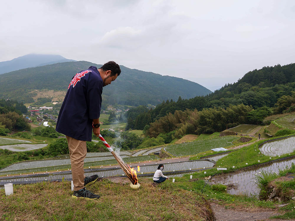 たいまつでろうそくに明かりをつける