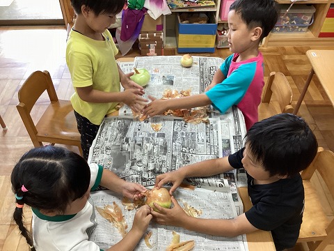 玉ねぎの皮をむく子ども達