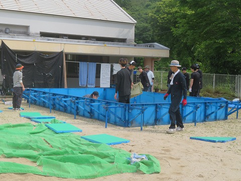 プール組み立てをする保護者