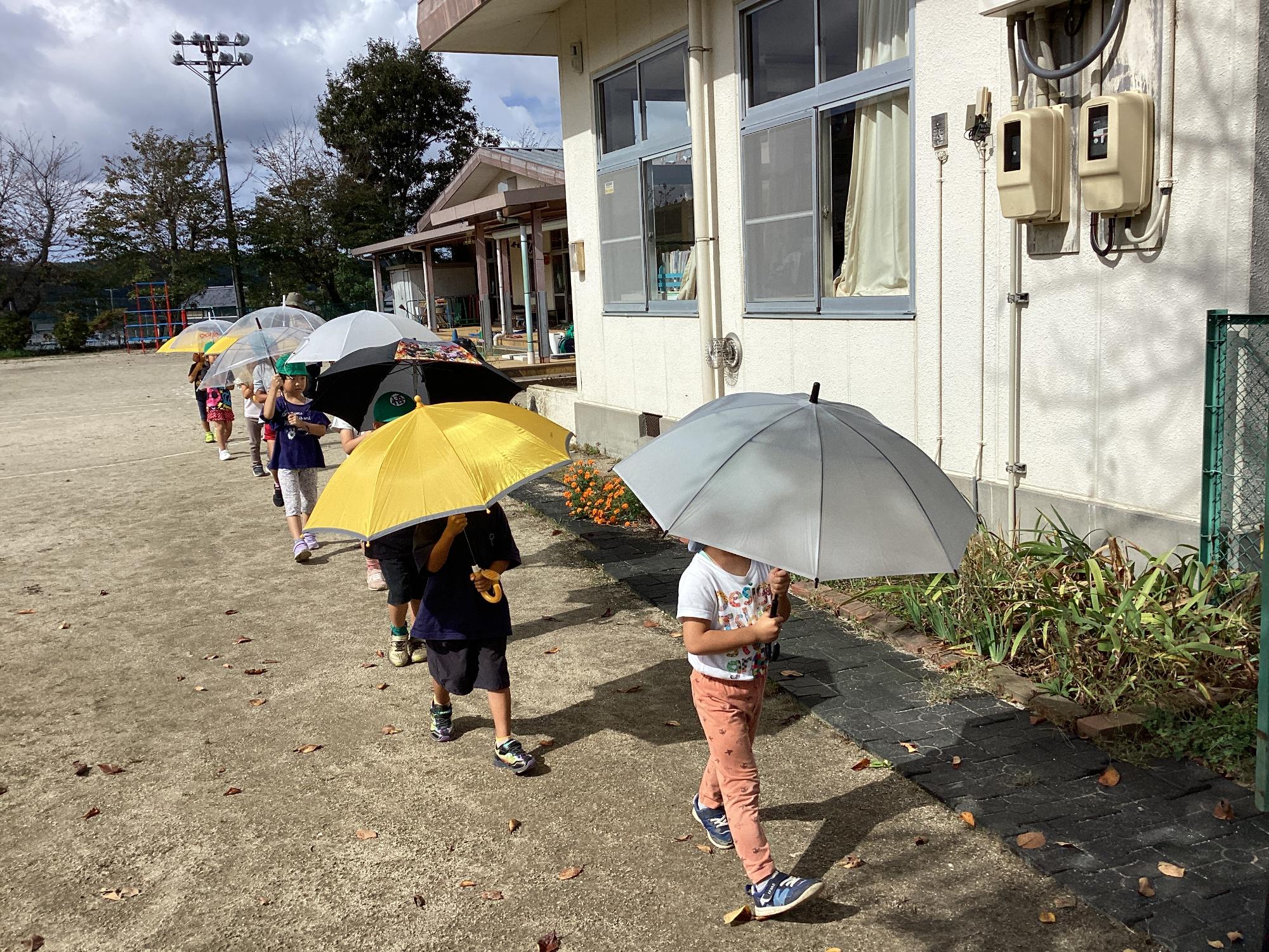 傘をさして歩く