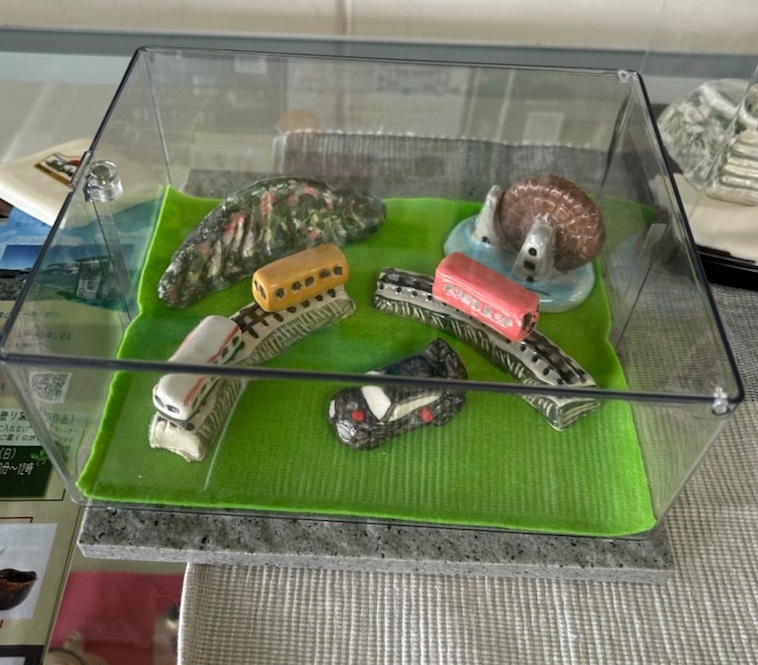 陶器で作った恵那市観光名所のジオラマ 山並み、明知鉄道、ラリーカー、おばあちゃん市山岡水車