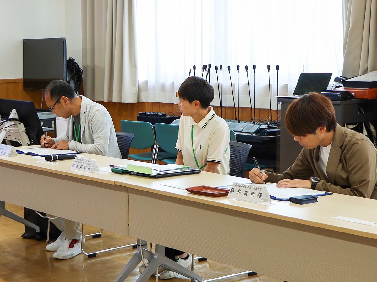協定書にサインする様子