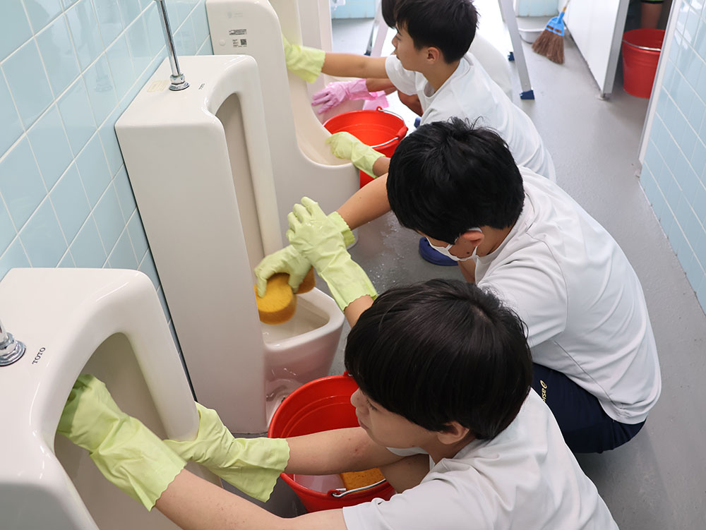 男子トイレを掃除する生徒ら
