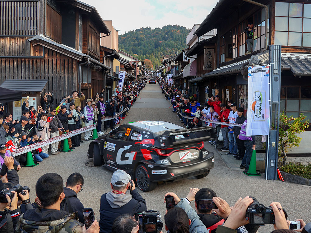 岩村リエゾン応援エリアを走るラリーカーにカメラを向ける観客ら