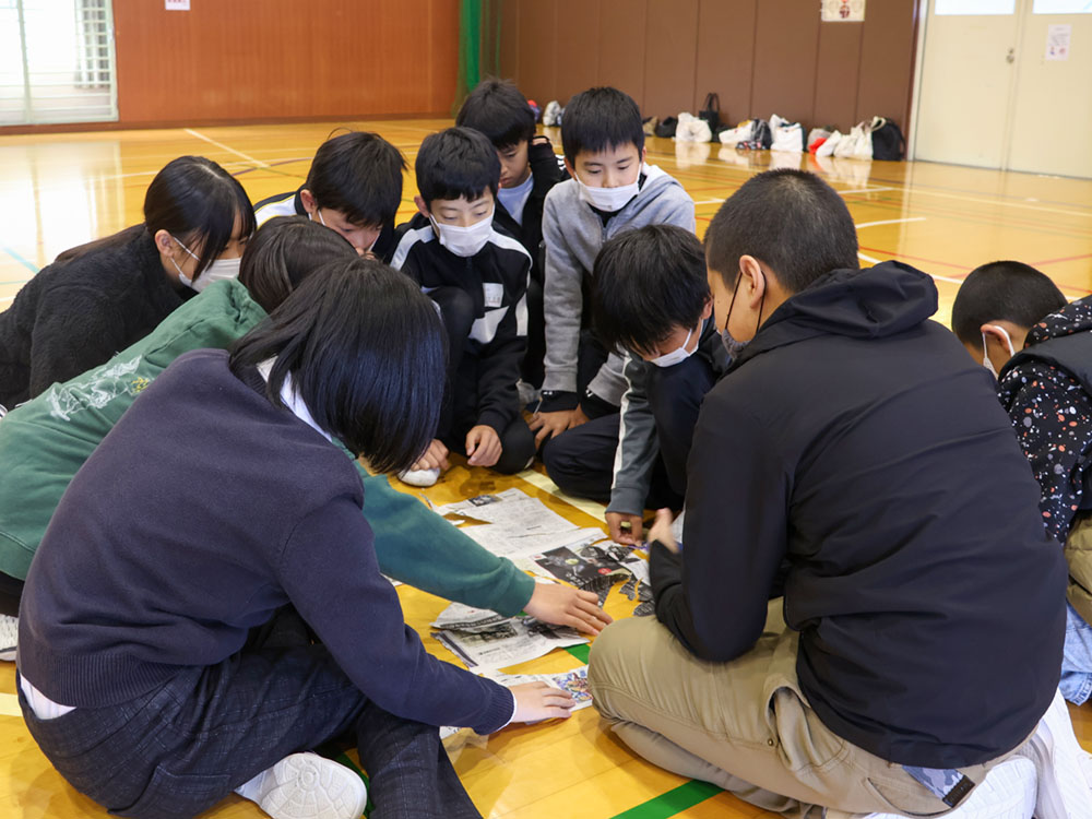 破った新聞紙をもとに戻すゲームをする児童ら