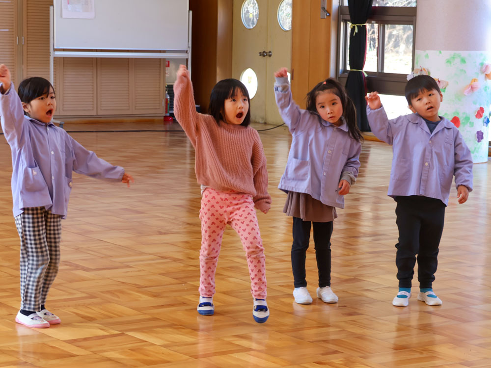 手を挙げて踊る園児