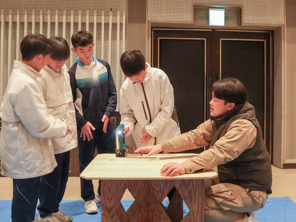 建築会社のブースで大工仕事を体験する中学生ら