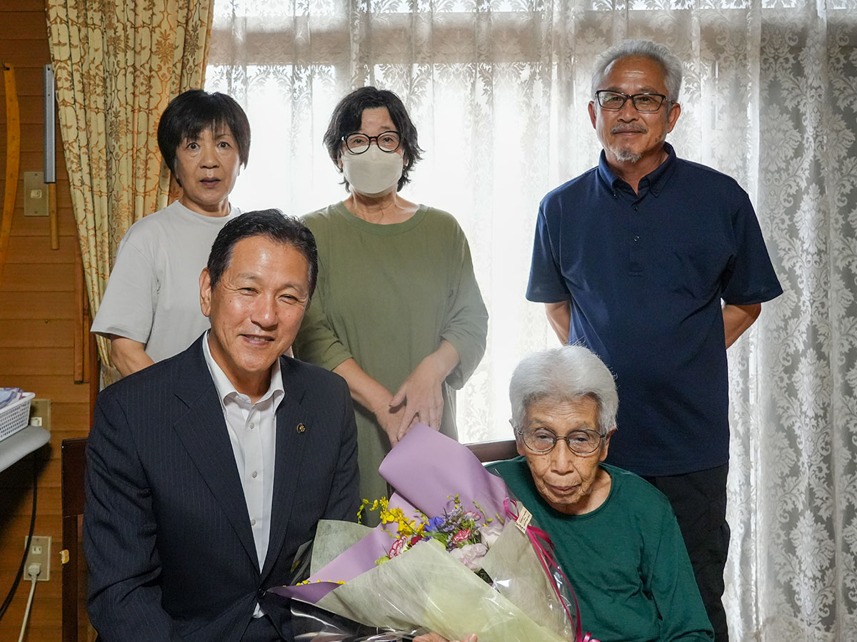 家族とともに花束を持つ樋田さん