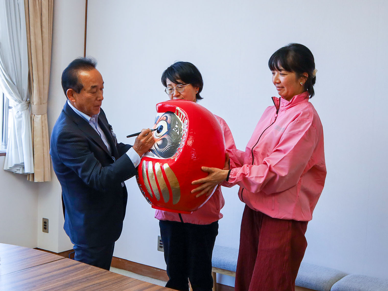 だるまに目入れを行う副市長