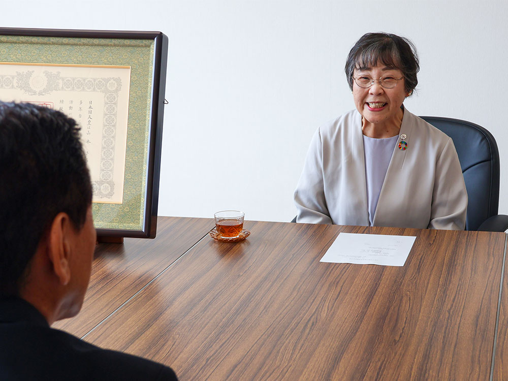 笑顔で市長に報告する山本さん