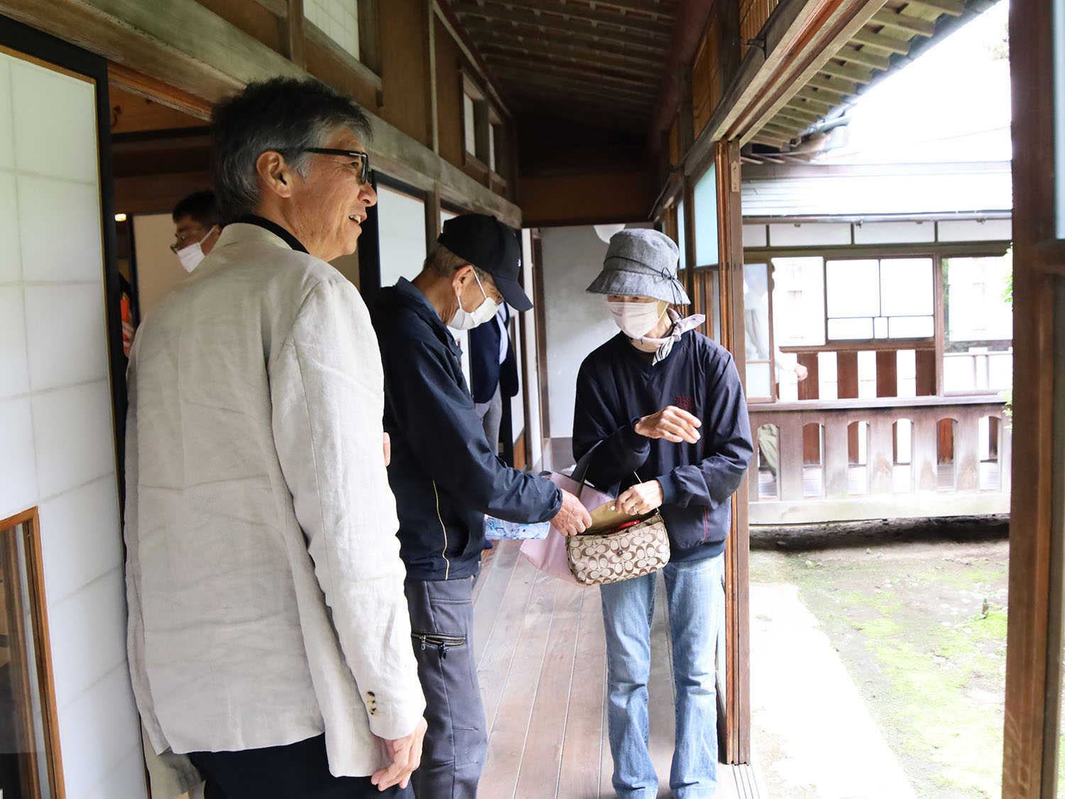 パネル展を訪れた来場者に撮影について説明する成島監督