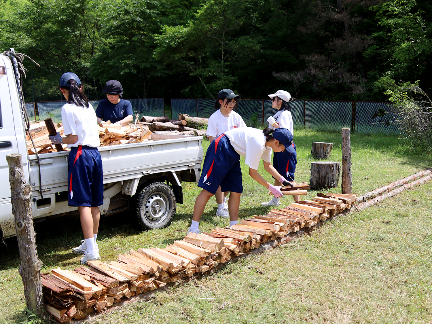 乾燥させるため薪を並べている串原中学校の生徒たち