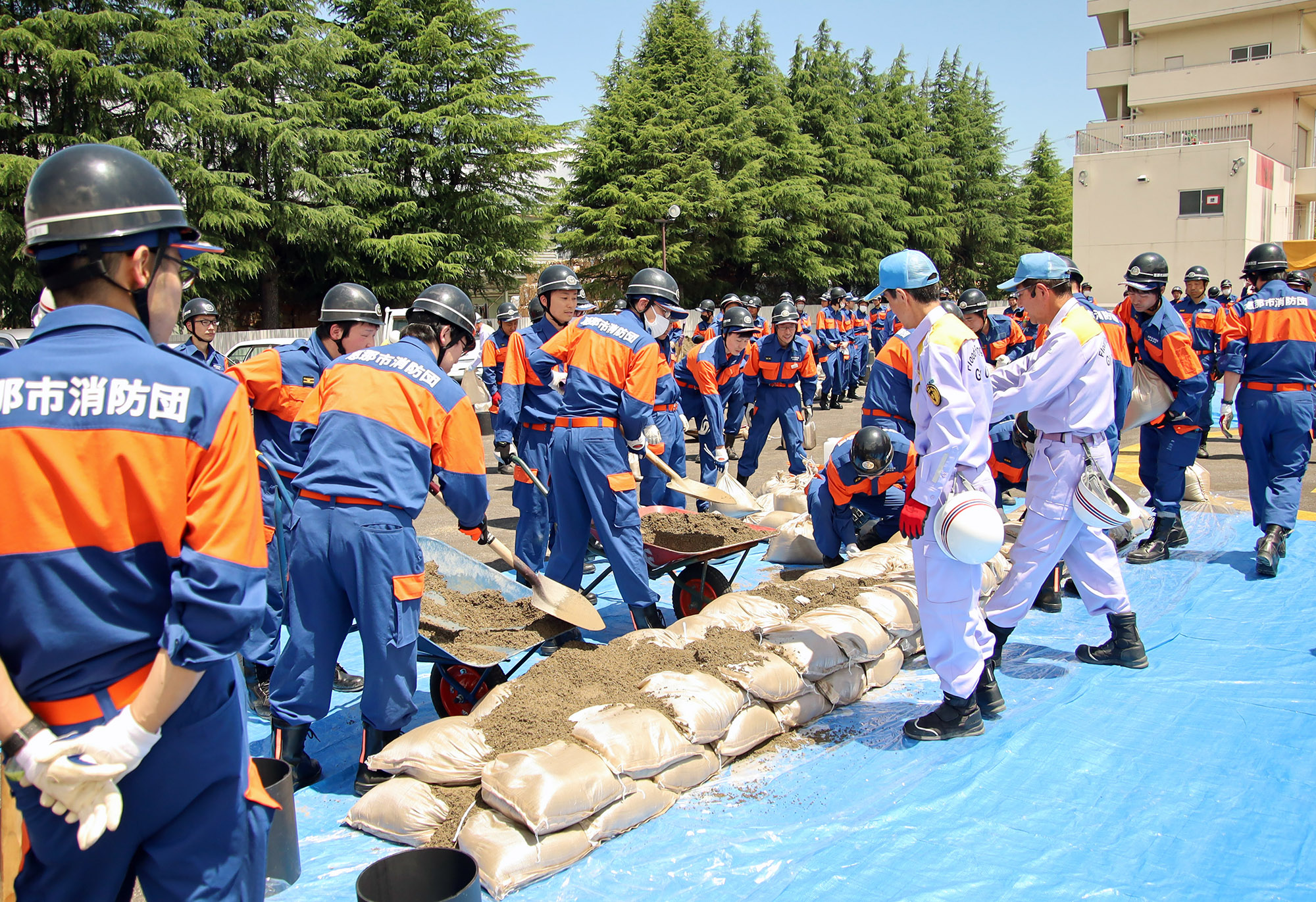 土のう積みの指示を受ける消防団員