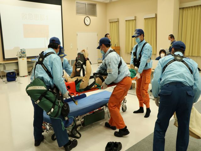 傷病者に見立てた人形を運ぶ救急隊員