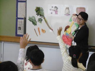 岩邑小学校にて生徒が給食を取りながら栄養教諭による授業を受けている様子