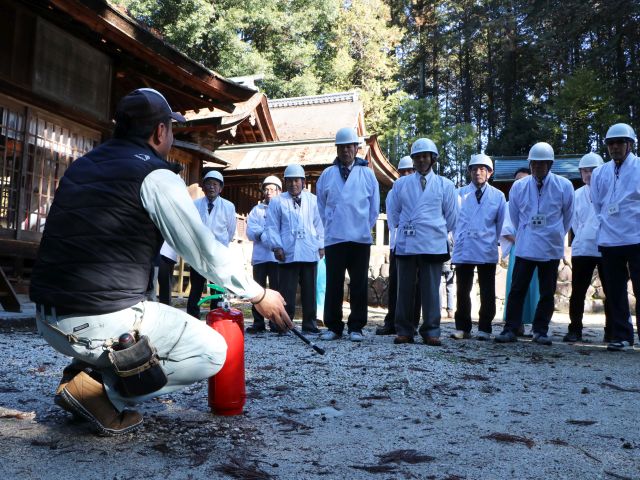 業者から消火器の使い方を学ぶ武並神社自衛消防隊員