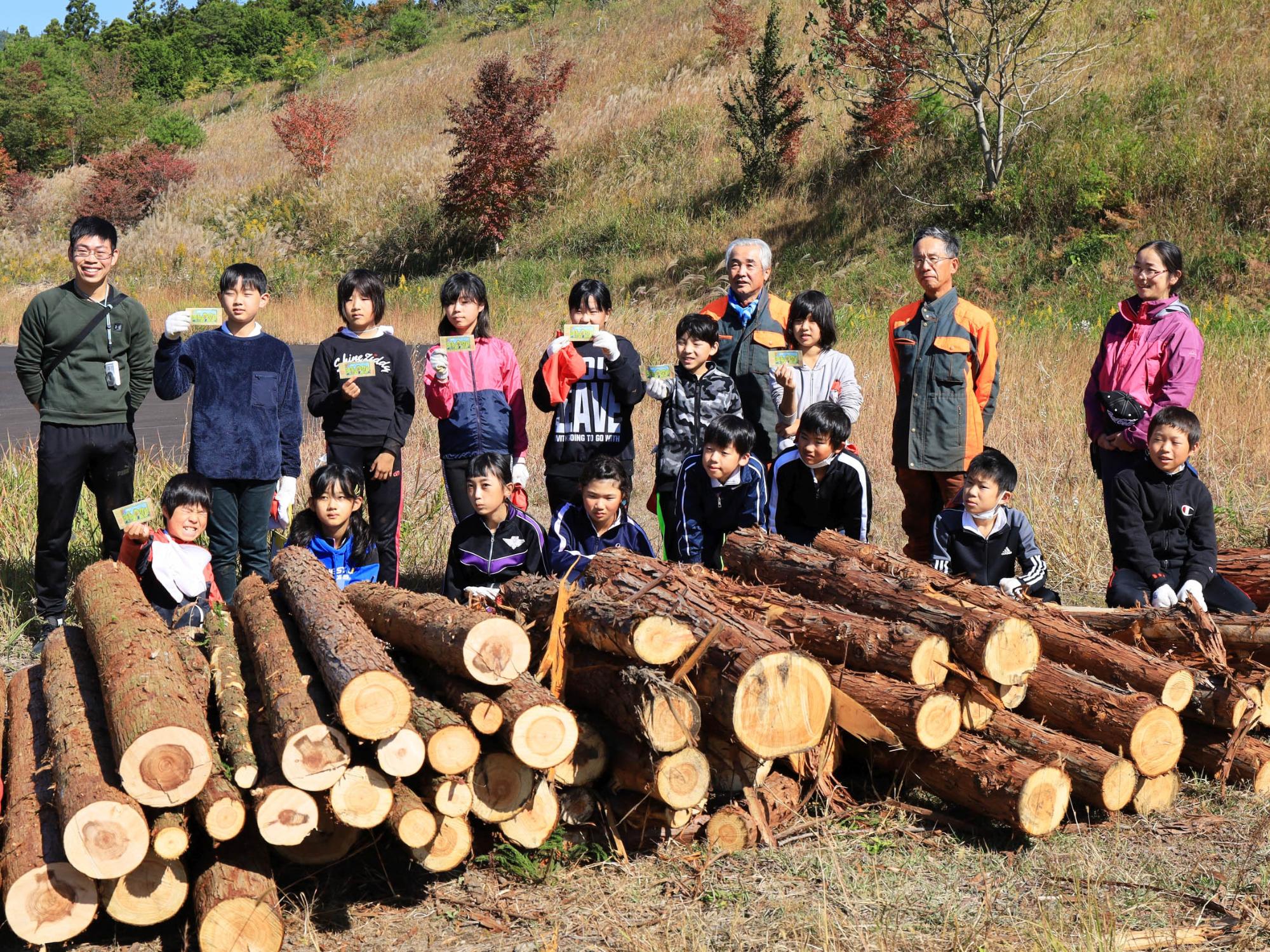間伐した木を前に記念撮影する中野方小学校5年生の児童ら
