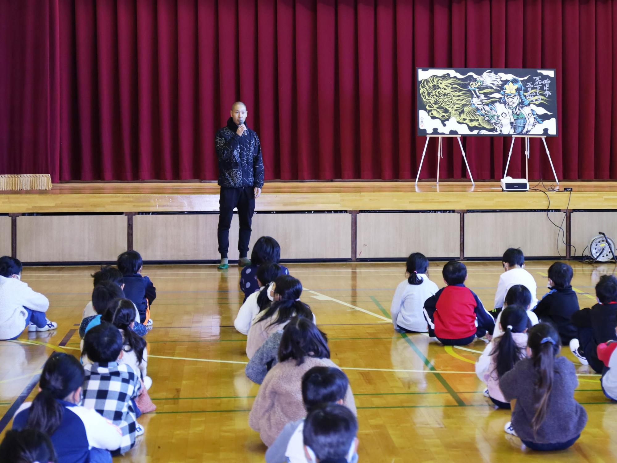 作品に込められた思いを児童らに伝える木全さん