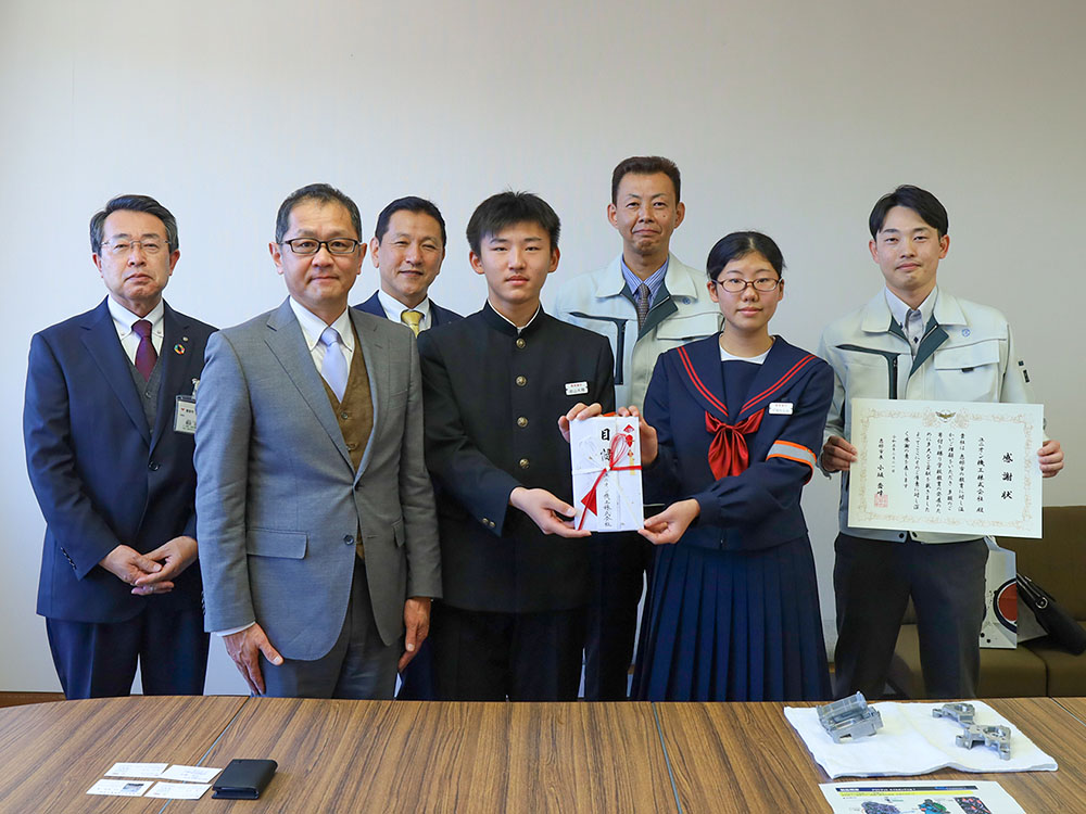 目録を受け取った恵那東中学校の生徒と、市からの感謝状を手にしたユニオン機工株式会社