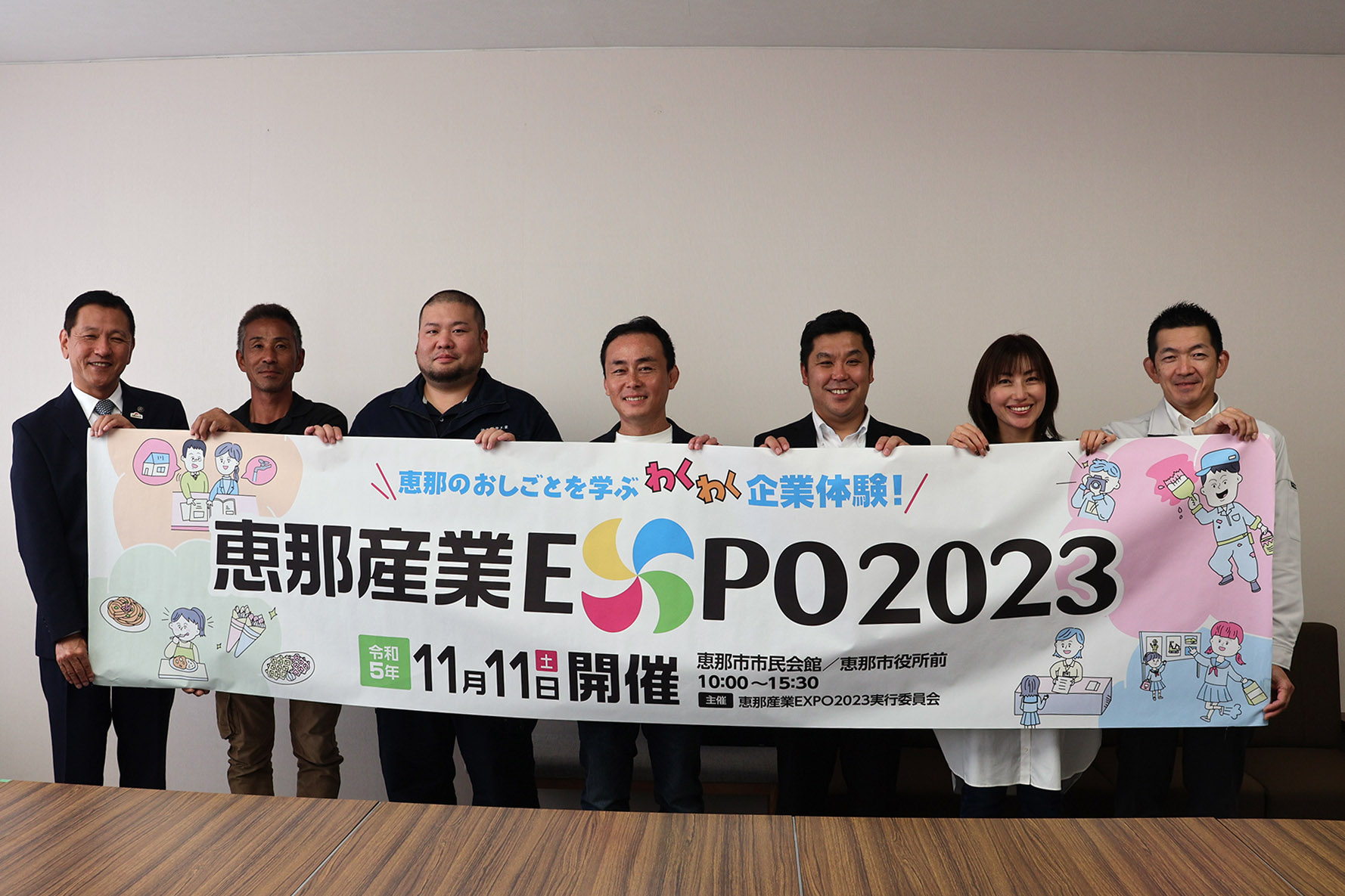 横断幕を持つ実行委員と小坂市長