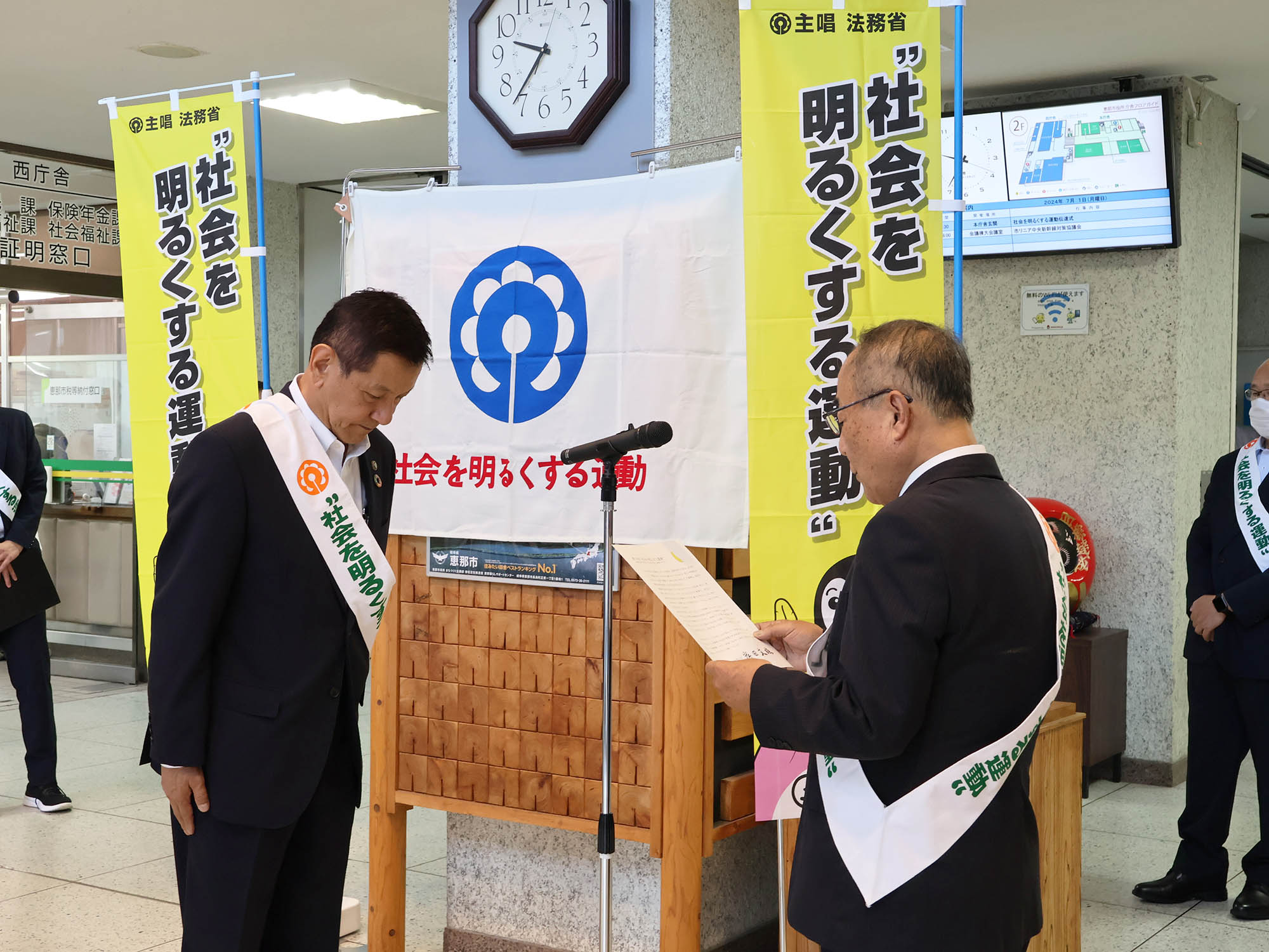 岡庭会長（右）から小坂市長（左）へ内閣総理大臣のメッセージを伝達