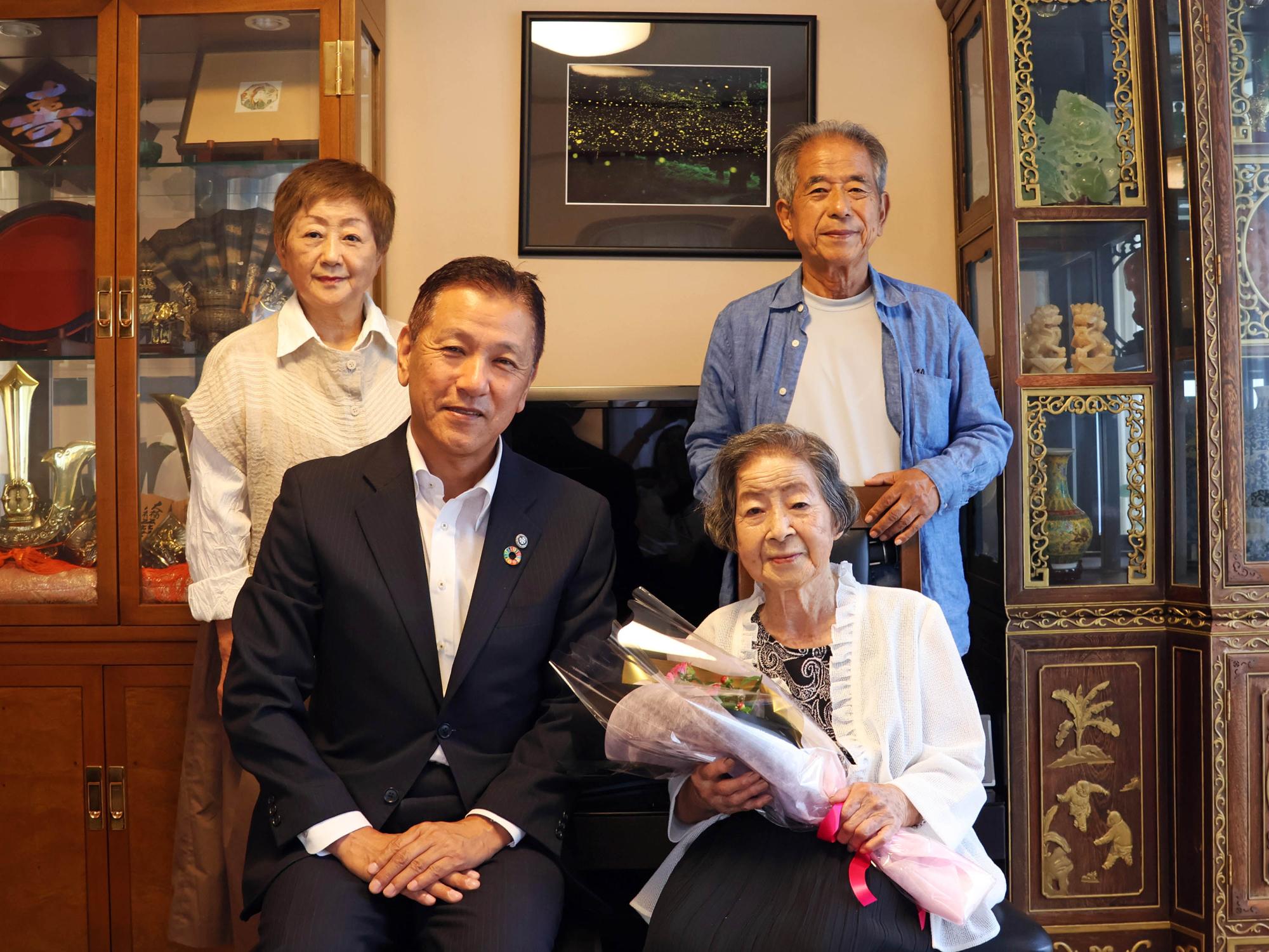 花束を持つ西尾さんと市長