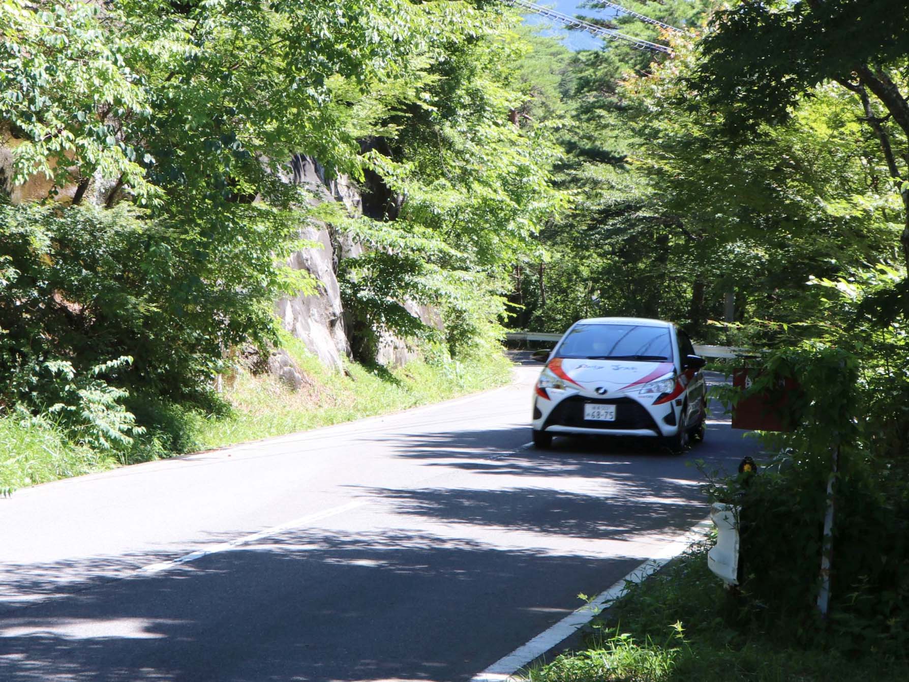 山道を疾走するラッピングカー