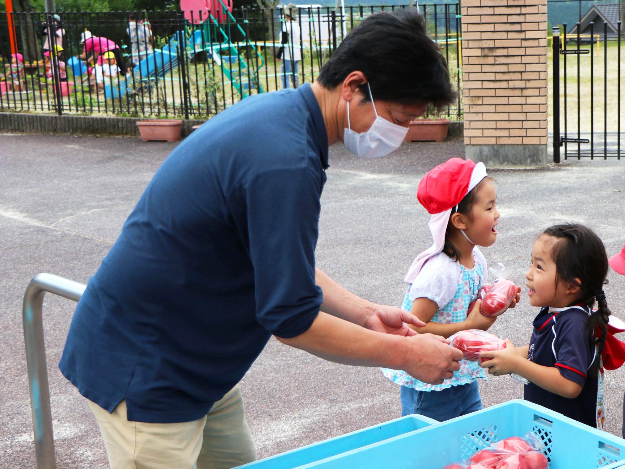 トマトを受け取り喜ぶ園児