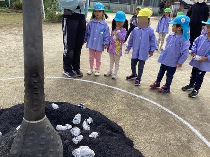 包んだ芋をもみの中に入れている。