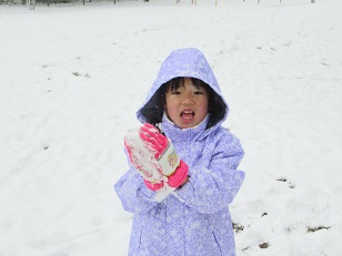 雪を握る子