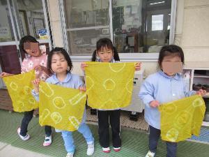 出来上がりの布を持つ子