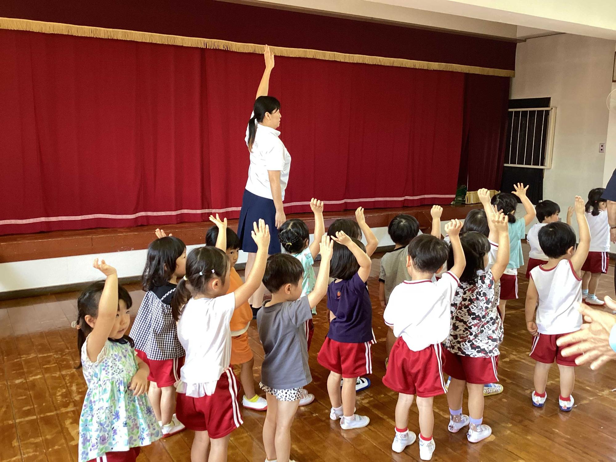 手を挙げて