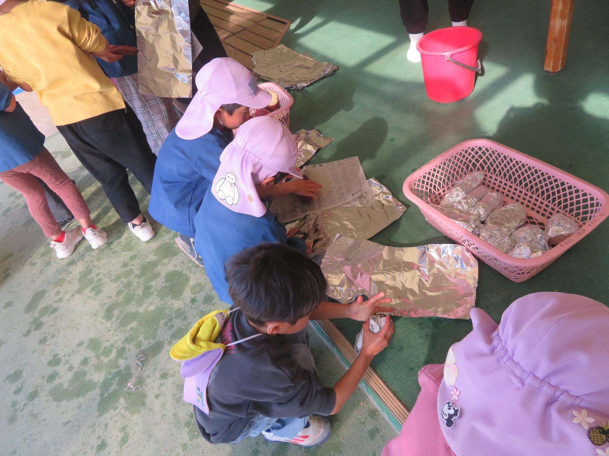 洗った芋を新聞紙、アルミホイルの順に包みました。