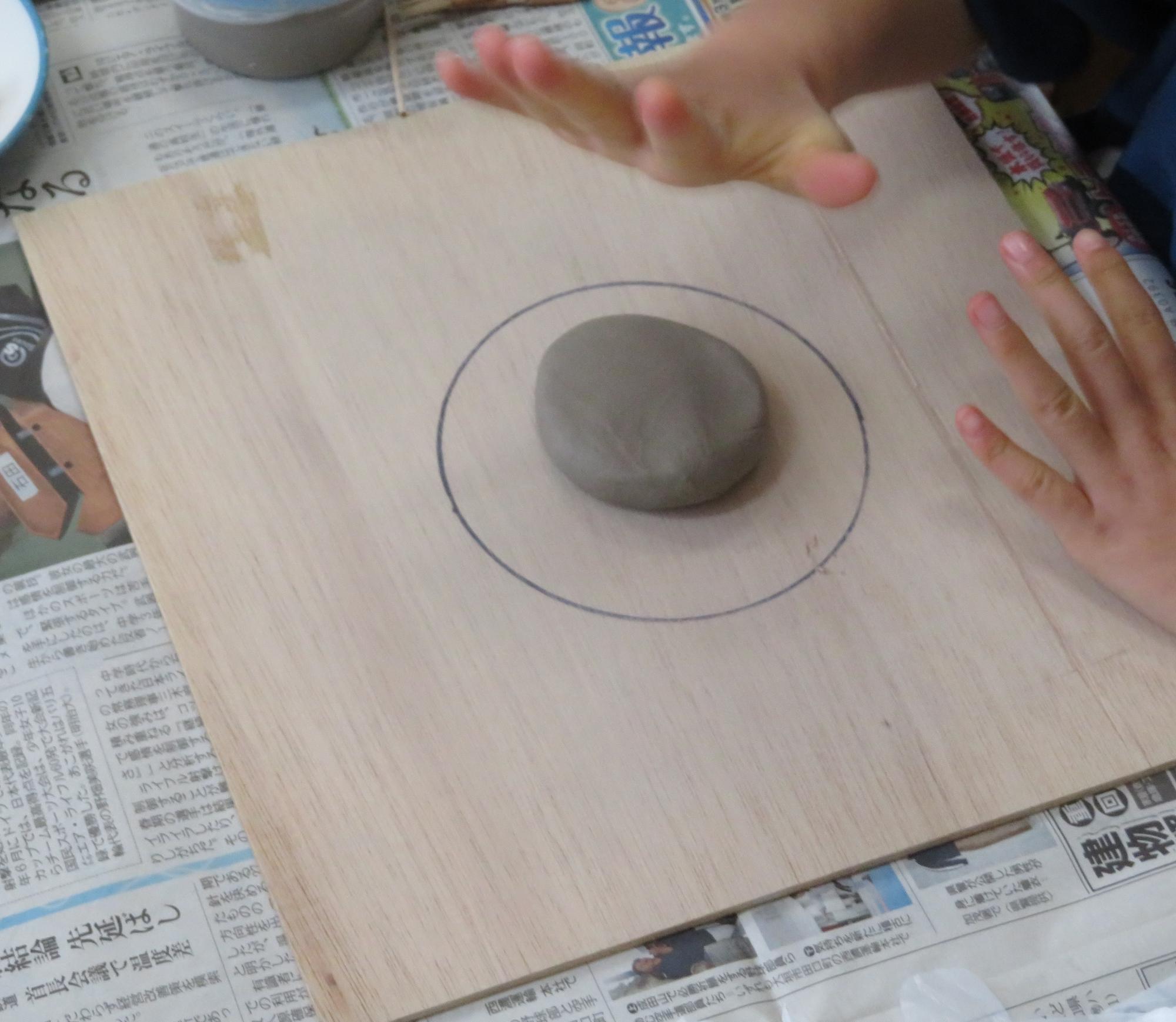 年長児は、土粘土を使ってお雛様づくりをしました。粘土を丸く叩いてつぶしていきます。