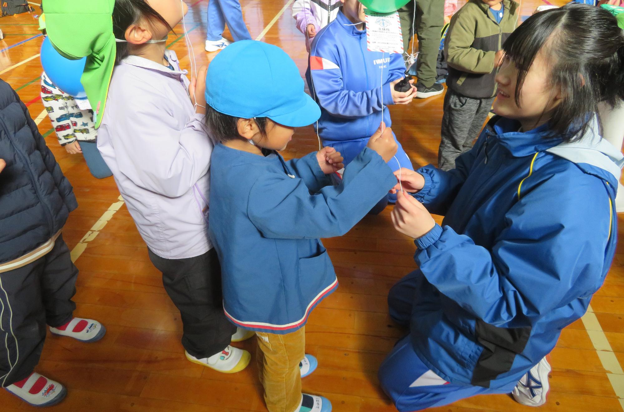 風船が飛ばない様に紐を輪っかに結んでくれるお姉さん