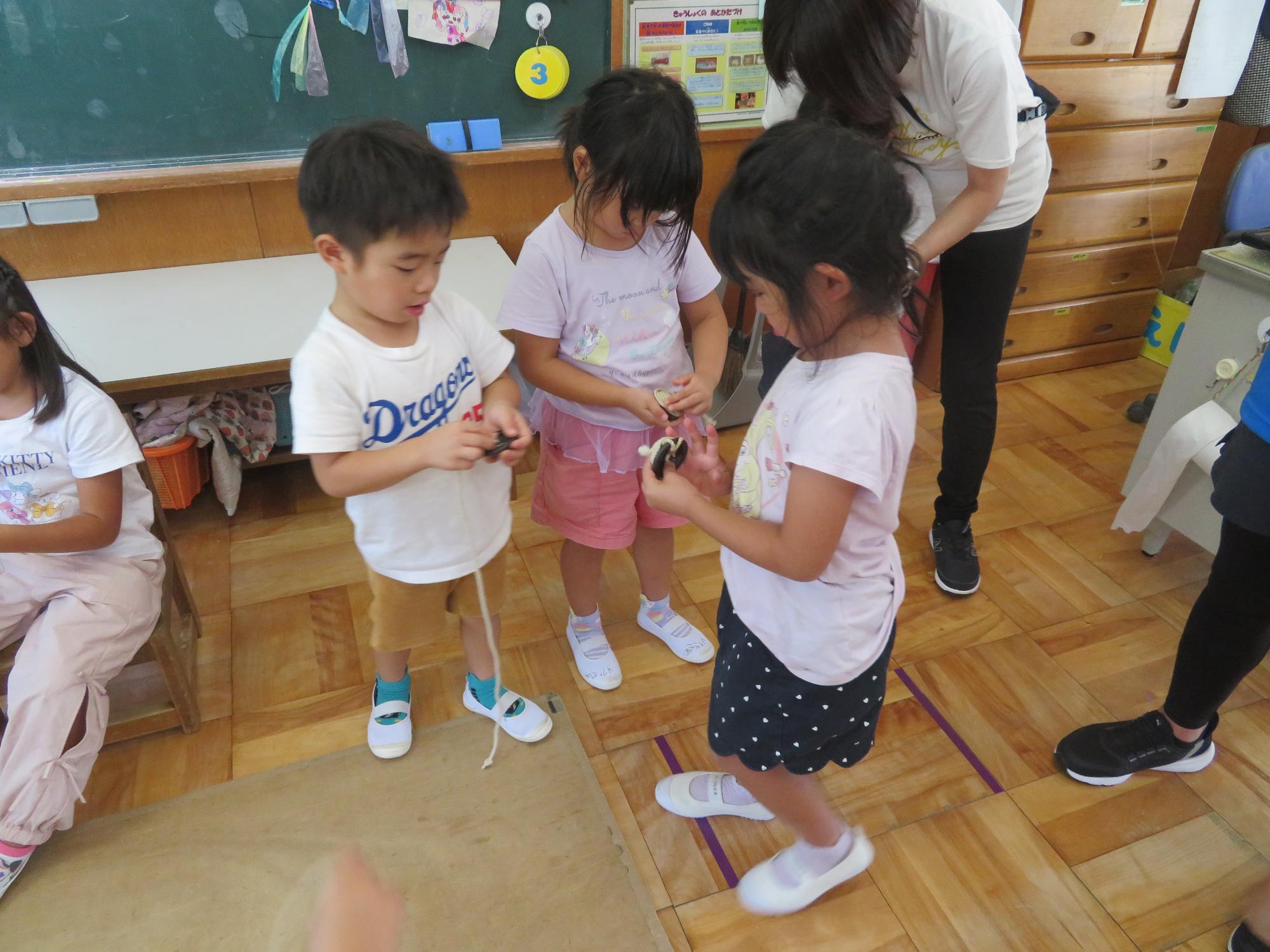 鉄ゴマの紐の巻き方を教えあっこしています