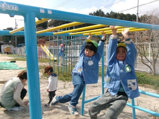 二人の子どもがうんていで遊んでいる様子