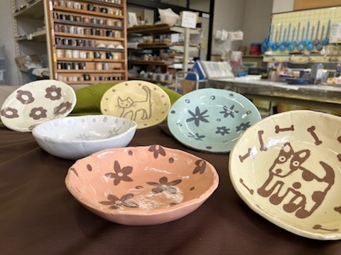 5月10日「カレー皿」浅めのサイズと深めのサイズがあります。内側に色粘土で好きな模様を描くことができます。講師が描いた花柄や犬の絵は世界で1つだけの皿になっています。